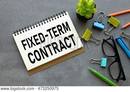 Fixed-term Contract Scattered Office Supplies On A Gray Background. Text On Notebook