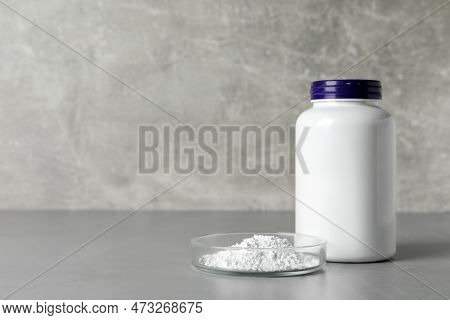 Jar And Petri Dish With Calcium Carbonate Powder On Grey Table. Space For Text