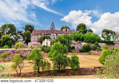 Old Abandoned Stone Country House In Catalonia, Surrounded By A Meadow And Trees