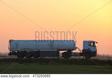 Semi-truck With Tipping Cargo Trailer Transporting Sand From Quarry Driving On Highway Hauling Goods