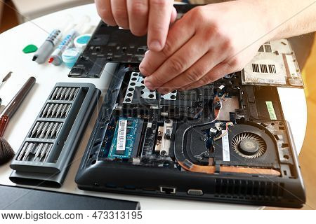 Repaiman With Screwdriver Fixing Disassembled Laptop Parts. Technical Support And Fixing Gadgets Pro