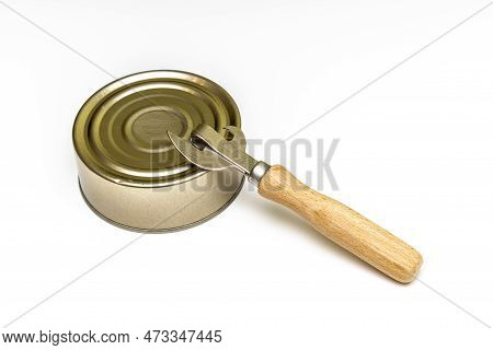 Old Tin Can With A Bottle Opener On A White Background. Closed Tin Can. High Quality Photo