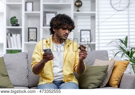 Cheated Man At Home Trying To Make Online Purchase And Money Transfer Sitting On Sofa In Living Room