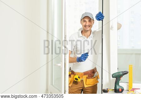 A Repairman Repairs, Adjusts Or Installs Metal-plastic Windows In The Apartment. Glazing Of Balconie