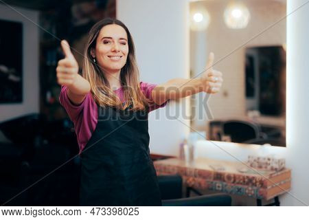Happy Hairdresser Standing In Hair Salon Holding Thumbs Up