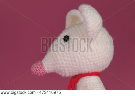 Amigurumi One White Mouse With Big Ears And Long Nose On A Pink Background. Side View, Close Up Port