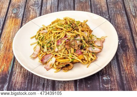 Tallarines Saltados Or Noodles Peruvian Style With Pieces Of Onion, Meat And Lots Of Parsley