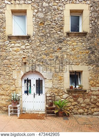 Stone House Facade With Windows And White Wooden Door And Stone Lintel. Stone Lintel Above Rustic Pa