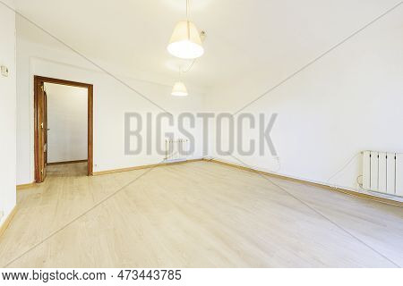 Living Room Of An Empty House With Sapele Doors And Light Wooden Flooring And Pendant Lamps From The