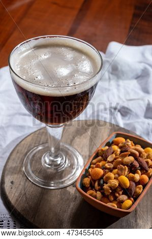 Glass Of Belgian Abbey Red Brown Beer And Glass Bowl With Party Nuts