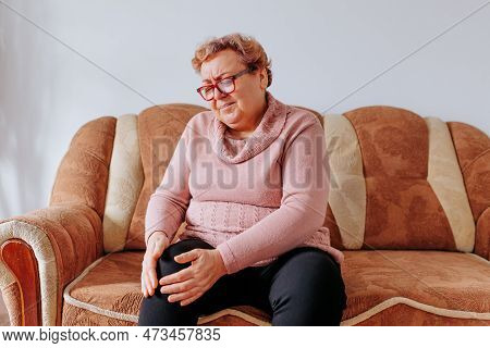 Aging Gracefully Managing Leg Pain At Home For Senior Women, An Aged Woman Trying To Relieve Her Leg