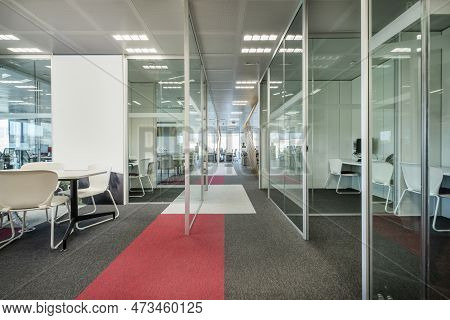 Work Offices With Glass Partitions To Separate Spaces With Carpeted Floors And Technical Ceilings