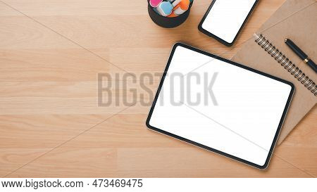Office Wooden Desk Workplace With Blank Screen Tablet And Smart Phone, Notebook And Pen, Top View Fl
