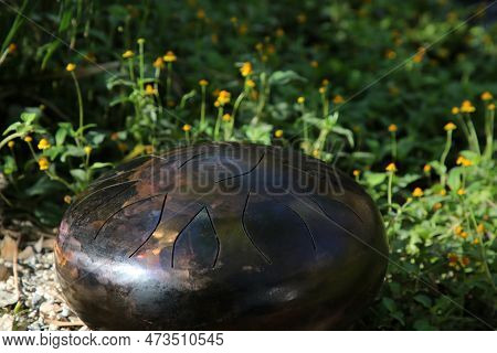 Steel Tongue Drum On Ground Outdoors. Percussion Musical Instrument