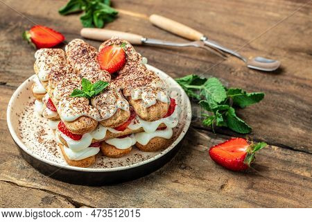 Tiramisu. Homemade Tiramisu With Fresh Strawberry, Mascarpone And Mint In Glass On Dark Background. 