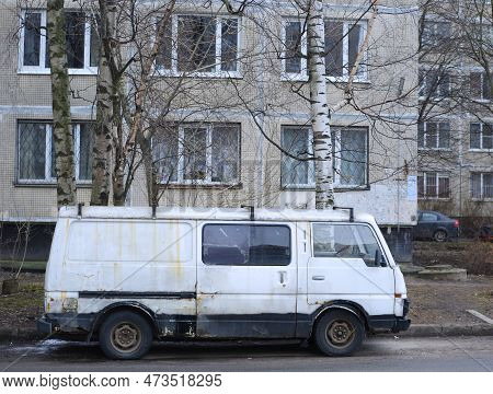 An Old Rusty White Minibus Is Parked In The Courtyard Of A Residential Building, Iskrovsky Prospekt,