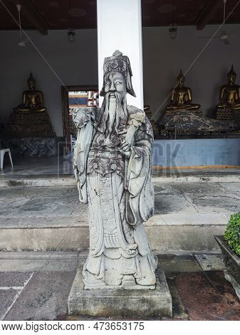 Cloister Of Wat Pho Temple With Chinese Guardian Statue. Wat Pho Is One Of The Oldest And Largest Te