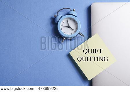 Quote Quiet Quitting On Yellow Sticker On Computer With Clock On Blue Background. Work Life Balance 