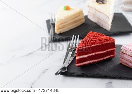 Set Of Cake Portions, Velvet, Strawberry Cake, Carrot Cake And Chocolate Cake On Marble. Copy Space