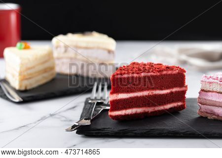 Set Of Cake Portions, Velvet, Strawberry Cake, Carrot Cake And Chocolate Cake On Marble.