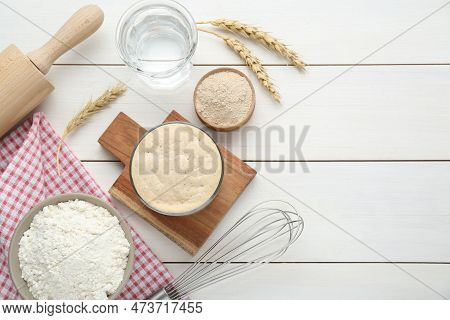 Leaven, Flour, Water, Rolling Pin, Whisk And Ears Of Wheat On White Wooden Table, Flat Lay. Space Fo