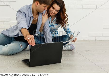 Portrait Of Happy Young Couple Using Laptop On Gray Background