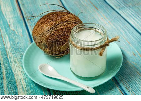 Coconut Oil And Fresh Coconuts On Old Vlue Wooden Table