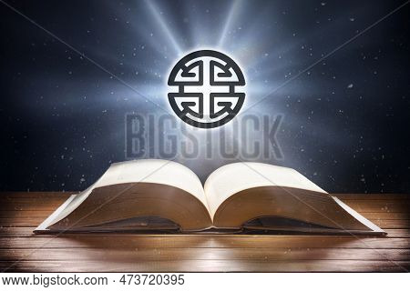Open Book On Wooden Table And Shenism Symbol With Beam Of Light With Dark Background. Front View.