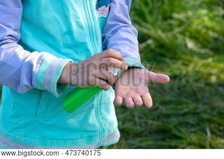 Girl Uses A Remedy For Mosquitoes And Biting Insects In Nature. Protection Of The Skin From Tick Bit