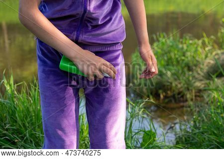 Girl Uses A Remedy For Mosquitoes And Biting Insects In Nature. Protection Of The Skin From Tick Bit