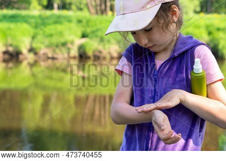 Girl Uses A Remedy For Mosquitoes And Biting Insects In Nature. Protection Of The Skin From Tick Bit