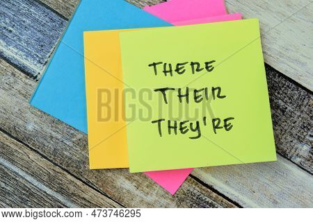 Concept Of There, Their, They're Write On Sticky Notes Isolated On Wooden Table.