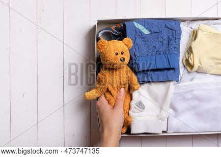 Second Hand, Circular Fashion Concept. Female Hands Put Childrens Toys And Clothes Into A Donation B