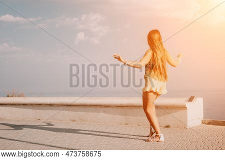 Woman Summer Dance. Silhouette Of A Happy Woman Who Dances, Spins And Raises Her Hands To The Sky. A