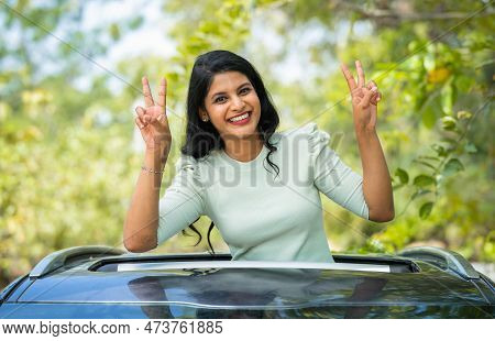 Happy Smiling Woman Showing Victory Sign By Looking At Camera On Car Sunroof - Concept Of Enjoyment,