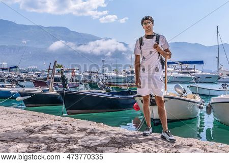 Young Adult Male Tourist Posing Near The Boats Moored On The Backdrop Of The Dukley Marina Port In B