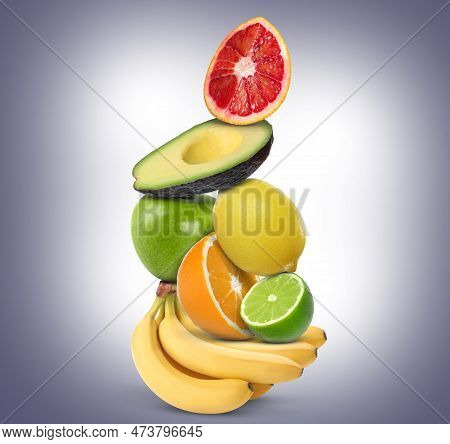 Stack Of Different Fresh Fruits On Pale Greyish Blue Gradient Background