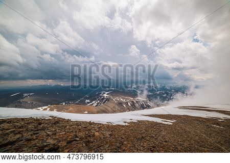 Awesome Top View Through Clouds To High Snowy Mountains. Scenic Landscape With Beautiful Snow Mounta