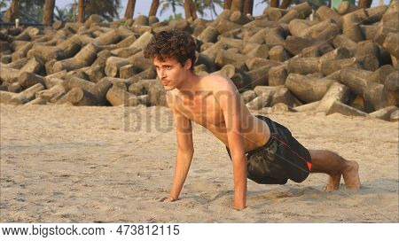 Man Doing Yoga On The Sandy Beatch. High Quality Photo