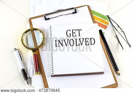 Get Involved Text On A Notebook With Clipboard On White Background
