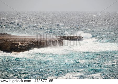 Ocean Shore During A Storm, Waves Crashing Against The Rock With Big Splashes. Dangerous, Windy Weat