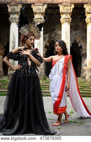 Portrait Of Two Women In Traditional Ethnic Red And White Saree And In Halloween Costume, Gothic Mak