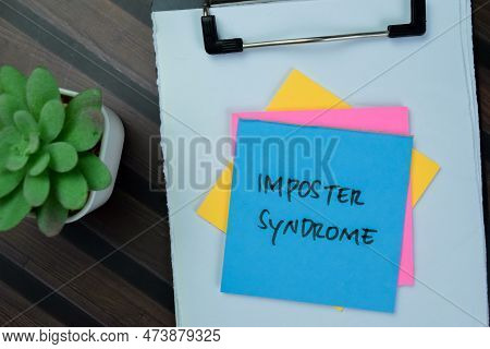 Concept Of Imposter Syndrome Write On Sticky Notes Isolated On Wooden Table.