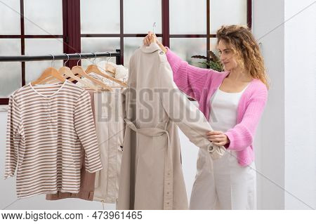 Shopping Concept. Young Beautiful Woman Choosing Trendy Clothes In Fashion Store