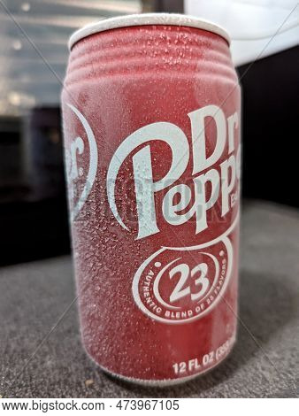 Frost Covered Vibrant Red Dr.pepper Soda Can Sitting On Top Of A Counter.