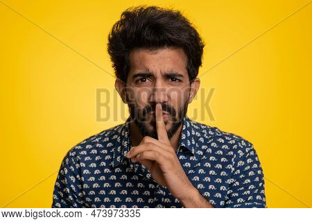 Shh Be Quiet Please. Young Indian Man Presses Index Finger To Lips Makes Silence Gesture Sign Do Not