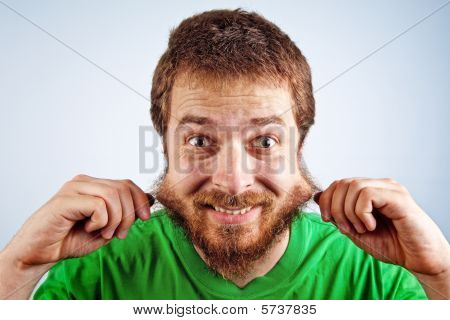 Engraçado homem bobo agarrando sua barba peluda