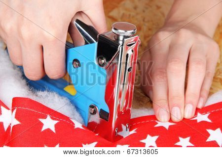 Fastening fabric and board using construction stapler