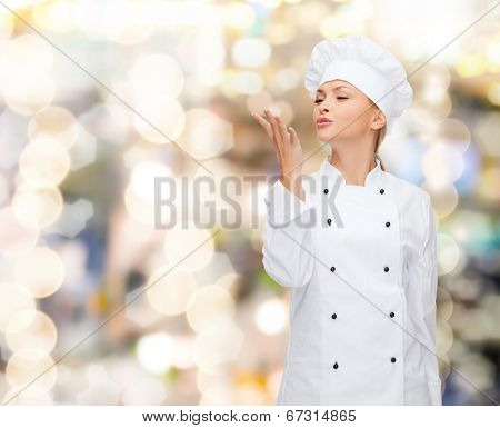 cooking, gesture and food concept - smiling female chef showing delicious gesture