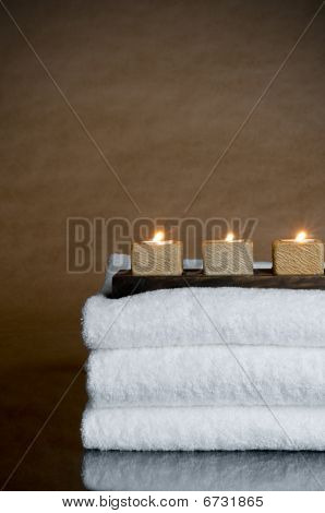 drei Kerzen auf drei Spa-Handtücher